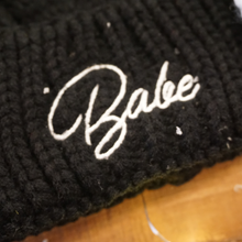 Load image into Gallery viewer, Soft black beanie with 'Babe' in white embroidery and faux fur pom-pom. Perfect for bachelorette parties or winter wear.