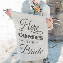 Load image into Gallery viewer, Here Comes the Bride&quot; Burlap Banner. This high-quality burlap banner is a perfect way to add additional children into your wedding, featuring a charming sign that reads &quot;Here Comes the Bride.&quot; Hang it from the entrance or wedding arch to create the perfect ambiance for your special day.
