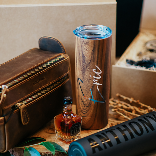 20 oz personalized stainless steel skinny tumblers for men, with lid and custom name. Perfect groomsmen cups for the wedding day. Image displays a groomsman proposal box with its collection of gift items.