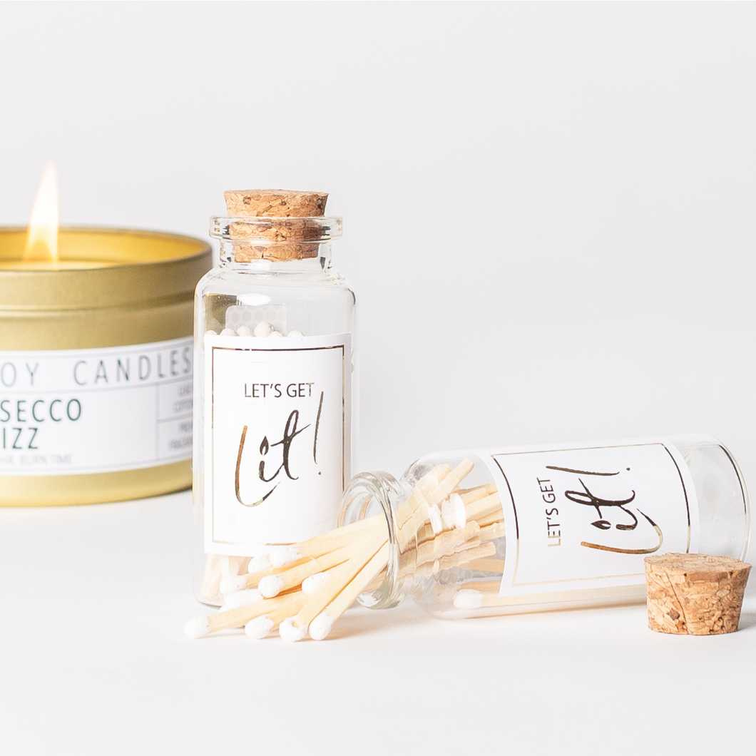 Decorative matches in a mini glass jar with cork lid and white label featuring gold foil writing that says “Let's Get Lit.” These matches are a great addition to bachelorette party favors and adult birthday party favors.